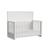 Wyller crib in white finish, angled view showing solid back panel and spindle sides
