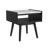 Lanette end table in black with white marble top, angled view showing open shelf and tapered legs