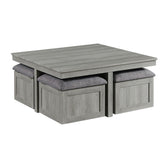 Uster coffee table in light gray wood grain finish, angled view with four gray upholstered storage stools tucked beneath