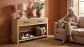 Ridgemont sofa table in Natural in a living room with lamp, vase, basket and cat on lower shelf